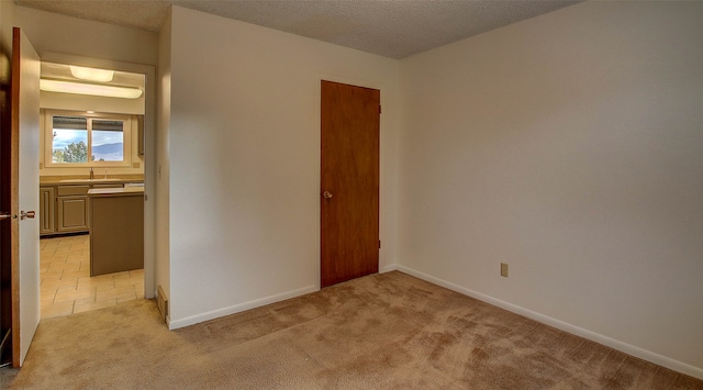 carpeted empty room with a textured ceiling