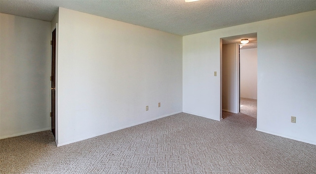 carpeted spare room featuring a textured ceiling