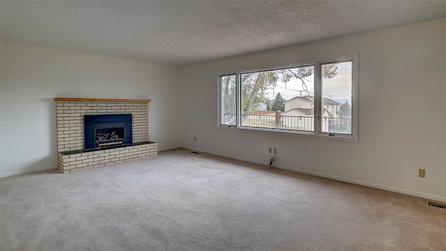 unfurnished living room with a textured ceiling, light colored carpet, and a fireplace