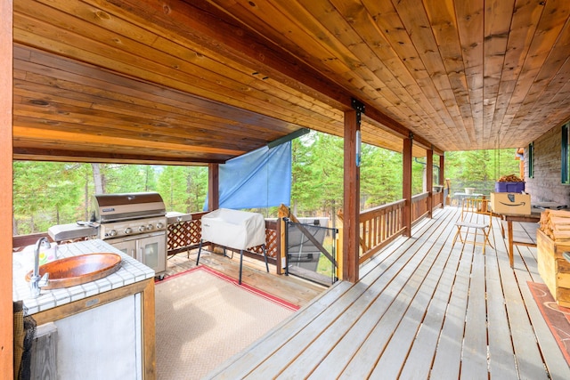 wooden terrace featuring area for grilling and sink