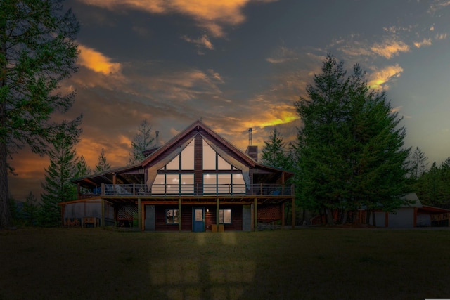 back house at dusk with a lawn