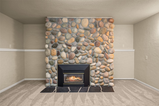 interior details with a stone fireplace, a textured ceiling, and carpet