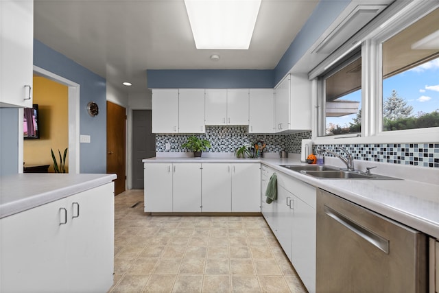 kitchen featuring dishwasher, decorative backsplash, sink, and white cabinets