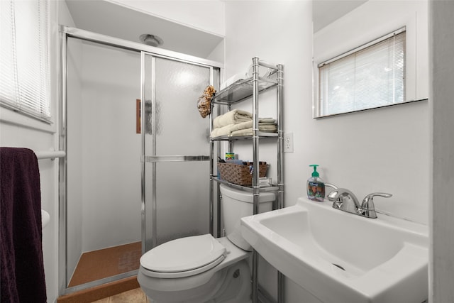 bathroom with toilet, a shower with shower door, and sink