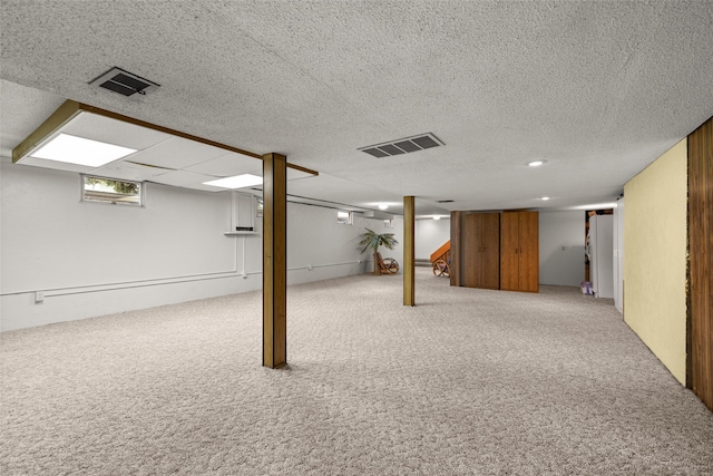 basement with carpet and a textured ceiling