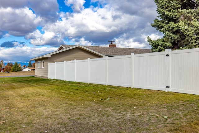 view of side of home with a yard