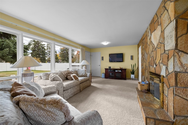 living room with a stone fireplace and carpet