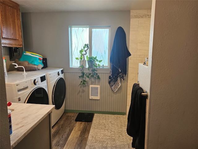 laundry room with cabinets, hardwood / wood-style floors, heating unit, and separate washer and dryer