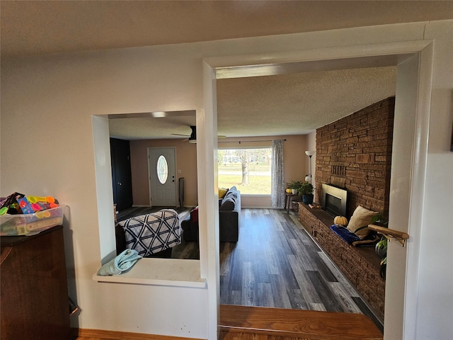 corridor with dark wood-type flooring and a textured ceiling