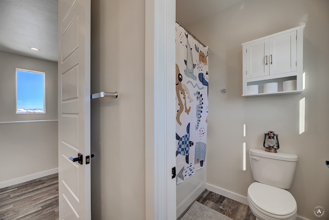 bathroom featuring hardwood / wood-style floors, a shower with shower curtain, and toilet