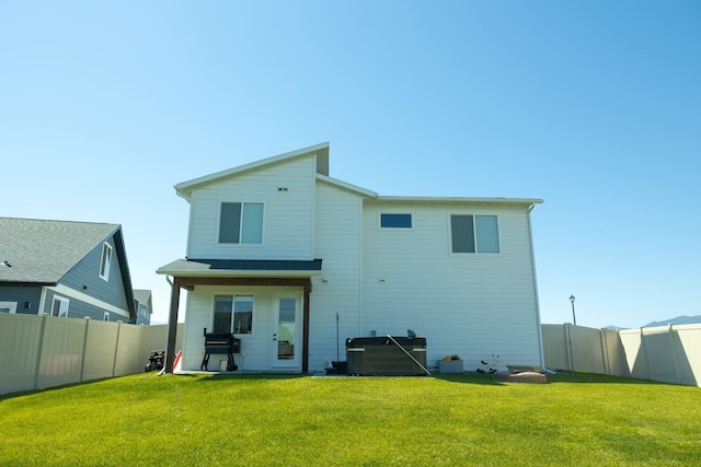 rear view of house featuring a lawn and a patio area