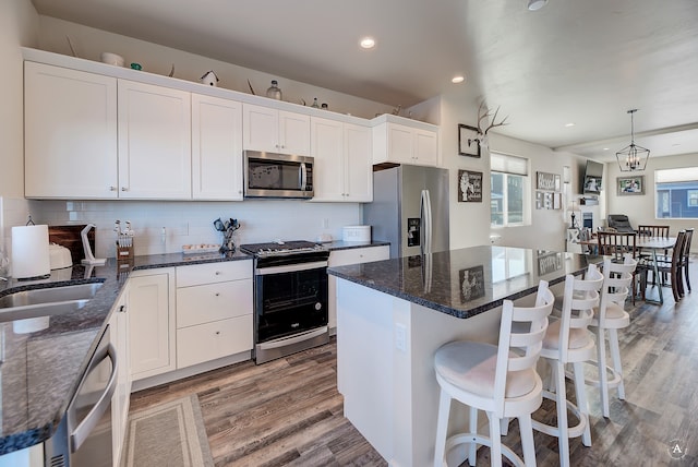 kitchen featuring stainless steel appliances, hanging light fixtures, a healthy amount of sunlight, and a kitchen island