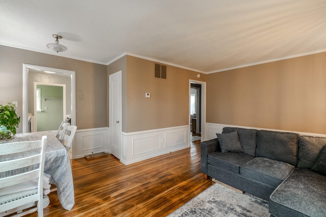 living room with crown molding and hardwood / wood-style floors