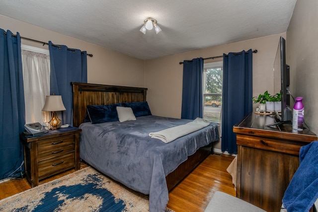 bedroom featuring hardwood / wood-style floors and a textured ceiling