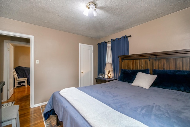 bedroom featuring dark hardwood / wood-style floors and a textured ceiling