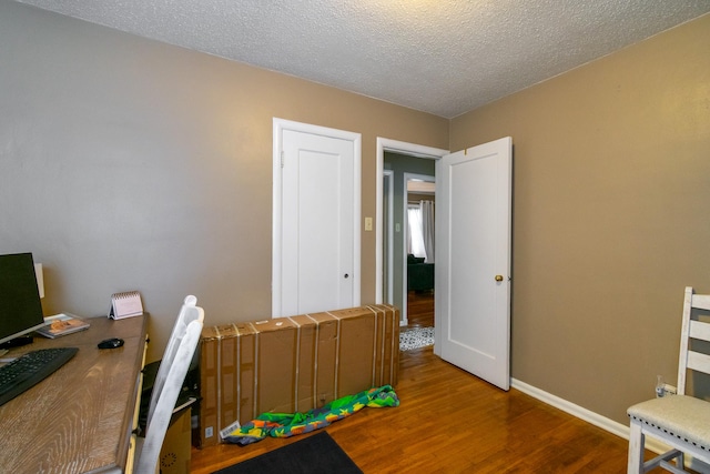 home office featuring hardwood / wood-style flooring and a textured ceiling