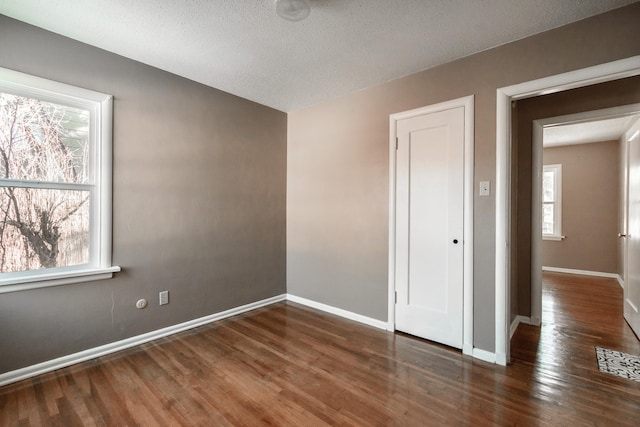 unfurnished room featuring dark hardwood / wood-style floors and a textured ceiling