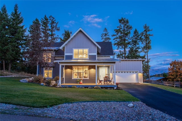 view of front of home featuring a porch, a garage, and a lawn