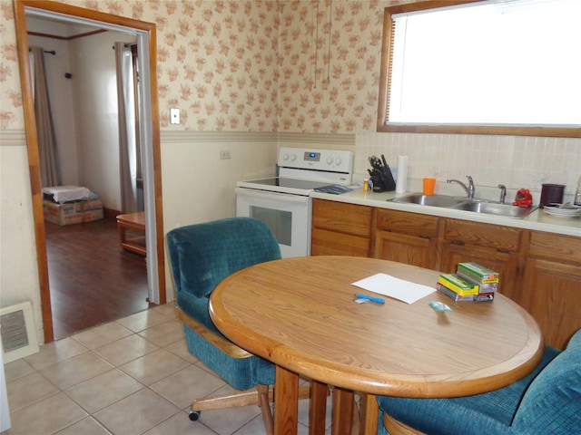 kitchen featuring light hardwood / wood-style flooring, sink, and electric range