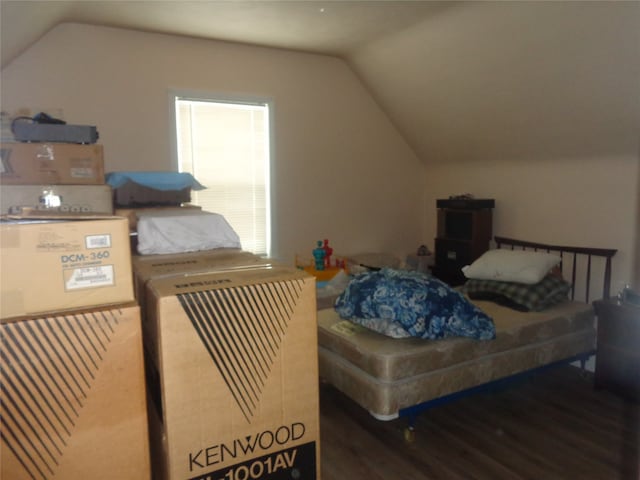 bedroom with vaulted ceiling and hardwood / wood-style flooring