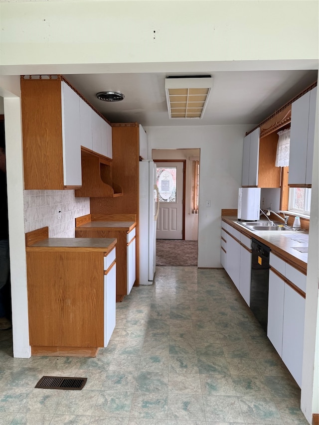 kitchen with decorative backsplash, white cabinets, dishwasher, sink, and white refrigerator