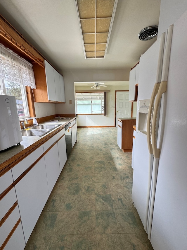 kitchen with white cabinetry, ceiling fan, white refrigerator with ice dispenser, and sink