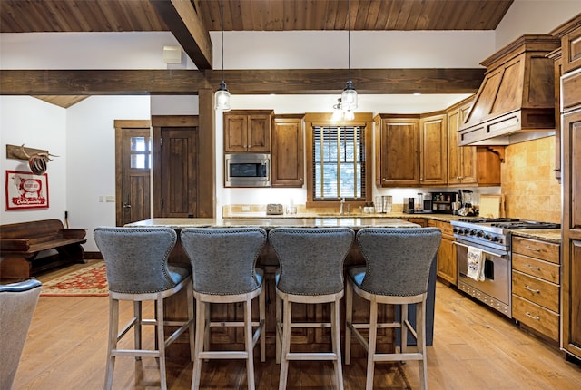 kitchen with beamed ceiling, custom exhaust hood, stainless steel appliances, and light wood-type flooring