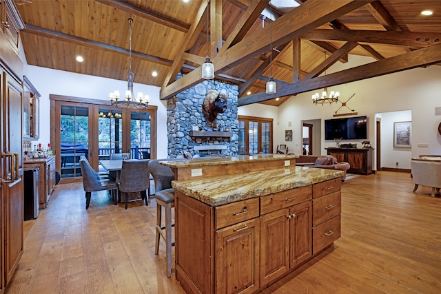 kitchen with a kitchen breakfast bar, a center island, pendant lighting, and french doors