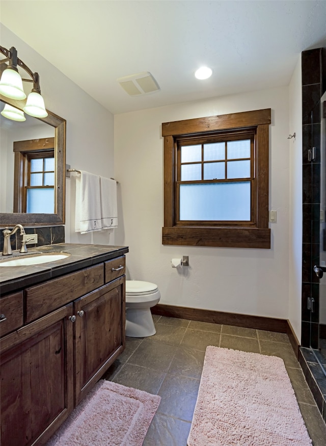 bathroom with vanity, toilet, plenty of natural light, and an enclosed shower