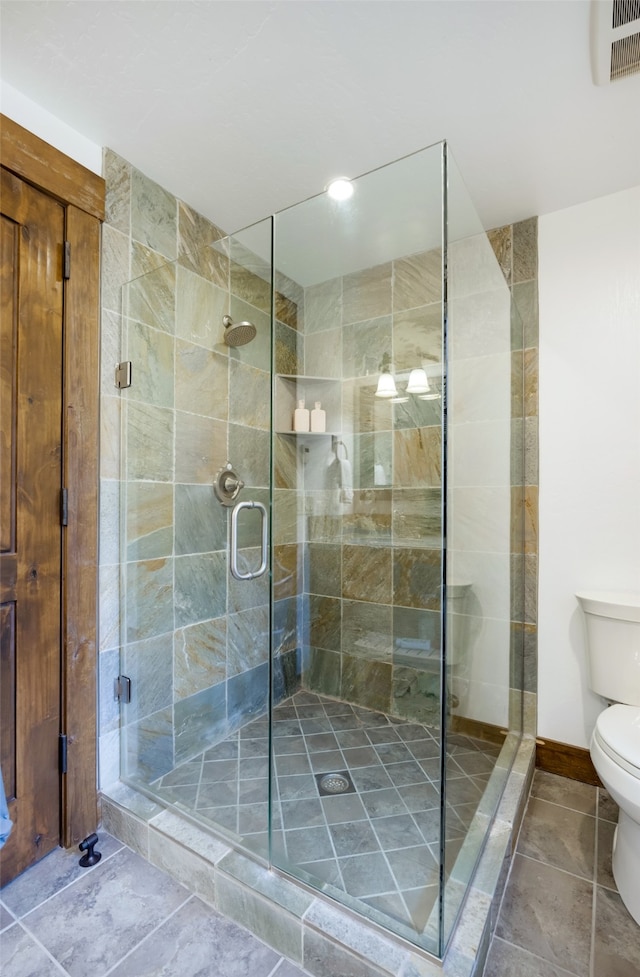 bathroom featuring toilet and an enclosed shower