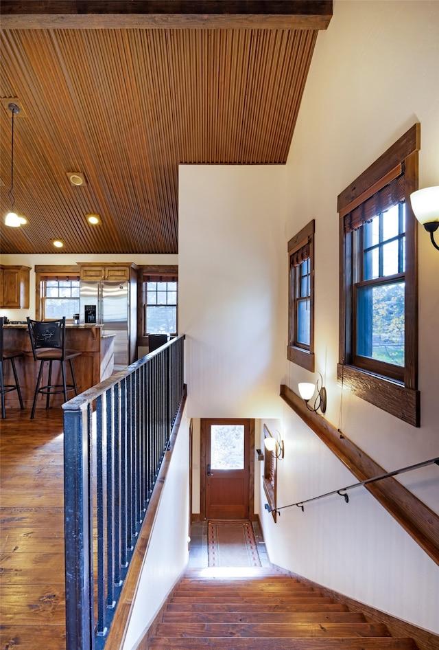 stairs with wood ceiling, hardwood / wood-style flooring, and plenty of natural light