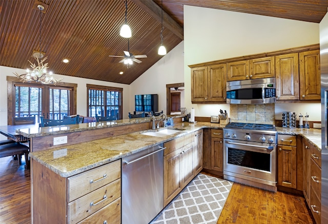 kitchen featuring sink, kitchen peninsula, stainless steel appliances, and dark hardwood / wood-style flooring