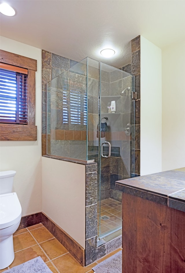 bathroom with tile patterned floors, toilet, and walk in shower