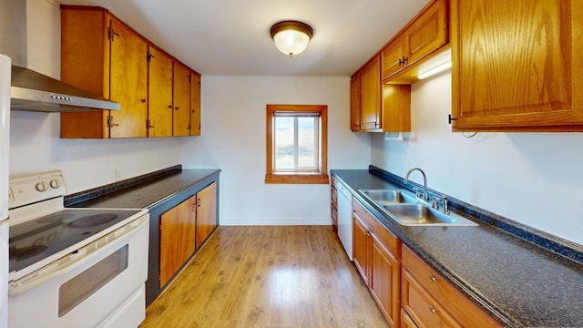 kitchen featuring white appliances, light hardwood / wood-style floors, wall chimney exhaust hood, and sink