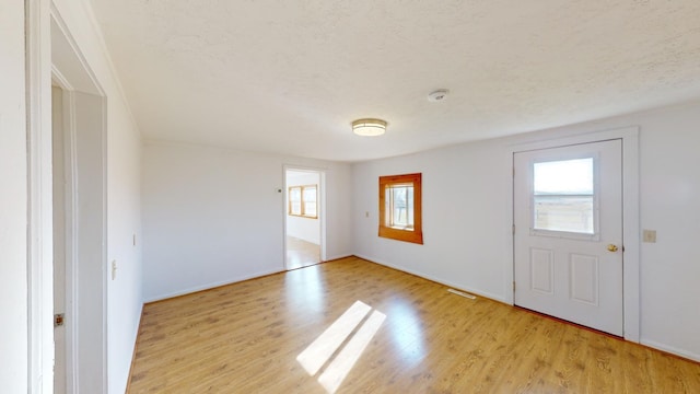 foyer with light hardwood / wood-style floors and a textured ceiling