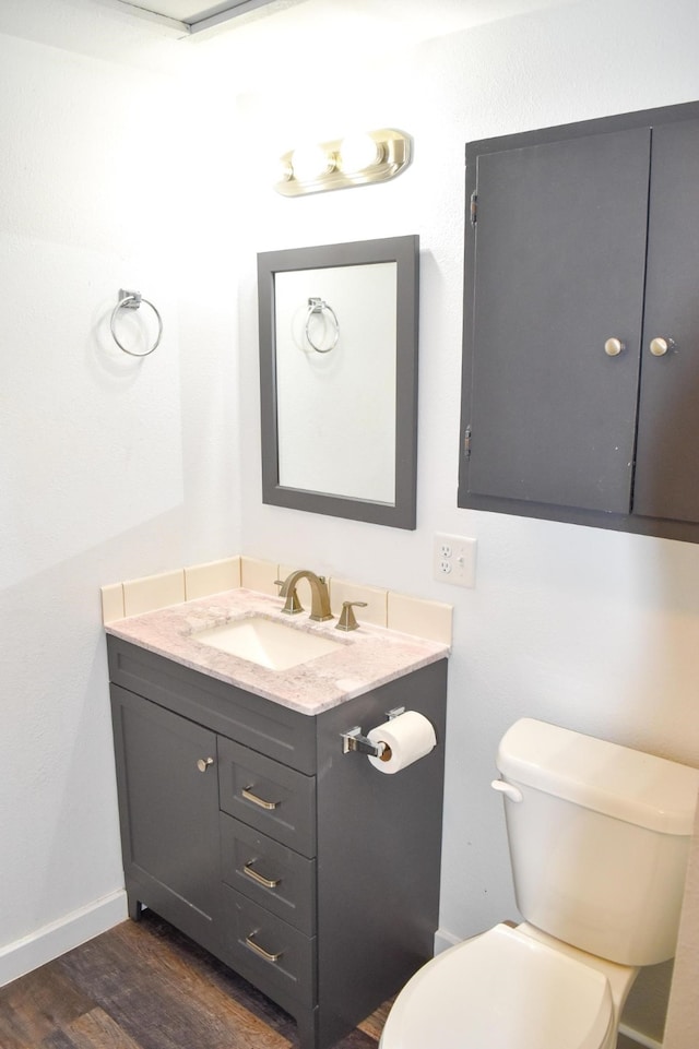 bathroom with vanity, hardwood / wood-style floors, and toilet