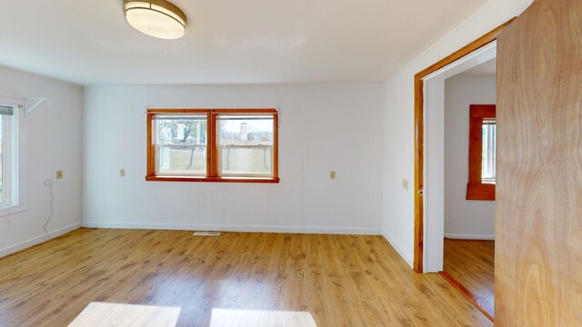 unfurnished room with a healthy amount of sunlight and light wood-type flooring