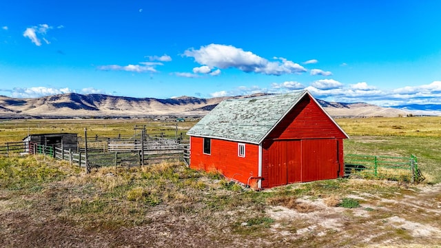 view of outdoor structure with a mountain view and a rural view