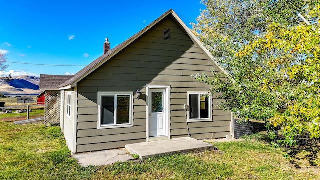 rear view of property featuring a lawn