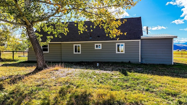 view of property exterior with a mountain view and a yard