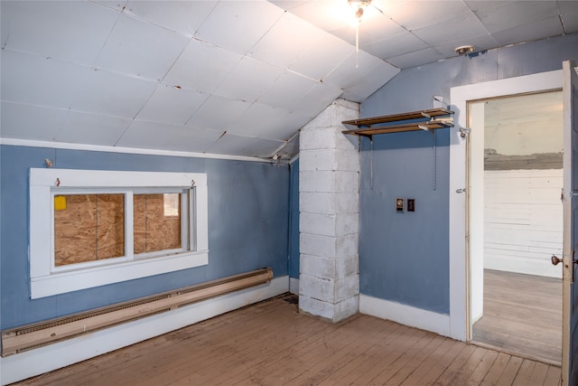 basement featuring baseboard heating and wood-type flooring