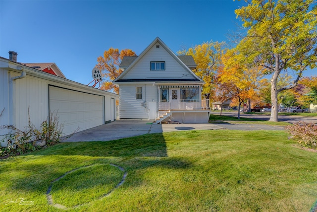 back of property with a porch, a garage, and a lawn