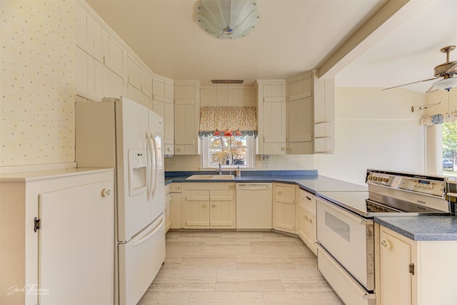 kitchen with white appliances, a healthy amount of sunlight, sink, and cream cabinetry