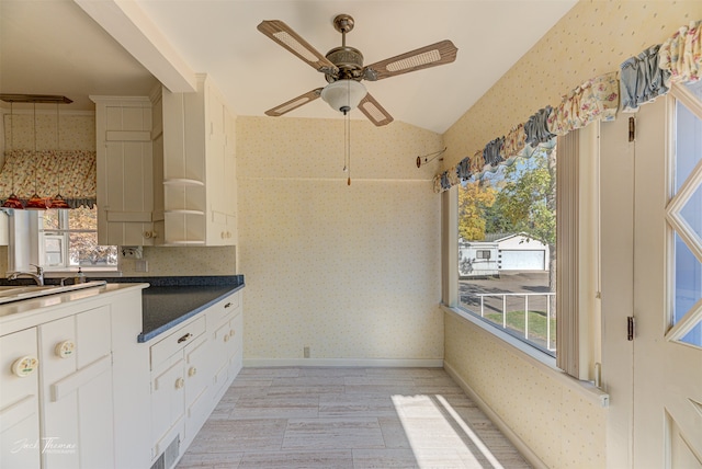 kitchen with white cabinetry, light hardwood / wood-style floors, lofted ceiling, and plenty of natural light