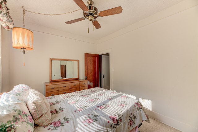 bedroom featuring a textured ceiling, carpet flooring, and ceiling fan