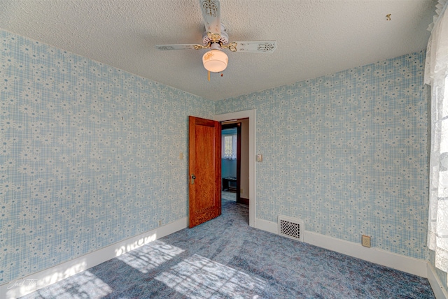 empty room with carpet, a textured ceiling, and ceiling fan