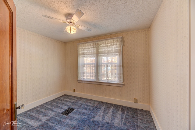 carpeted spare room featuring ceiling fan and a textured ceiling