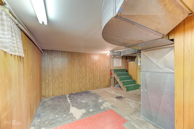 basement featuring wood walls