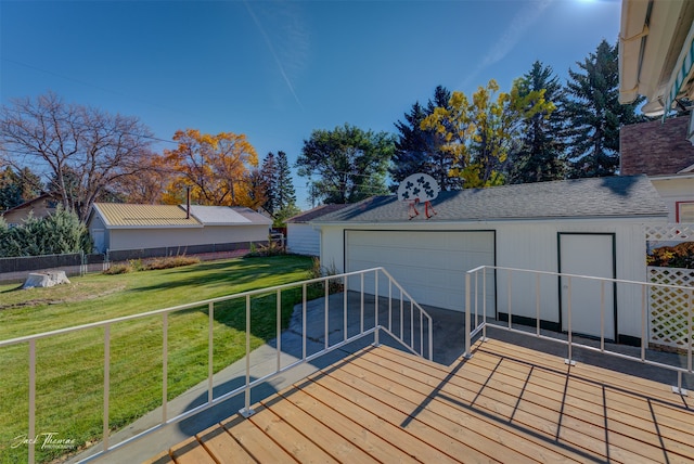 wooden terrace featuring an outbuilding, a yard, and a garage