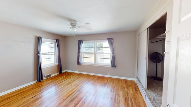 unfurnished bedroom with a closet, light wood-type flooring, and ceiling fan